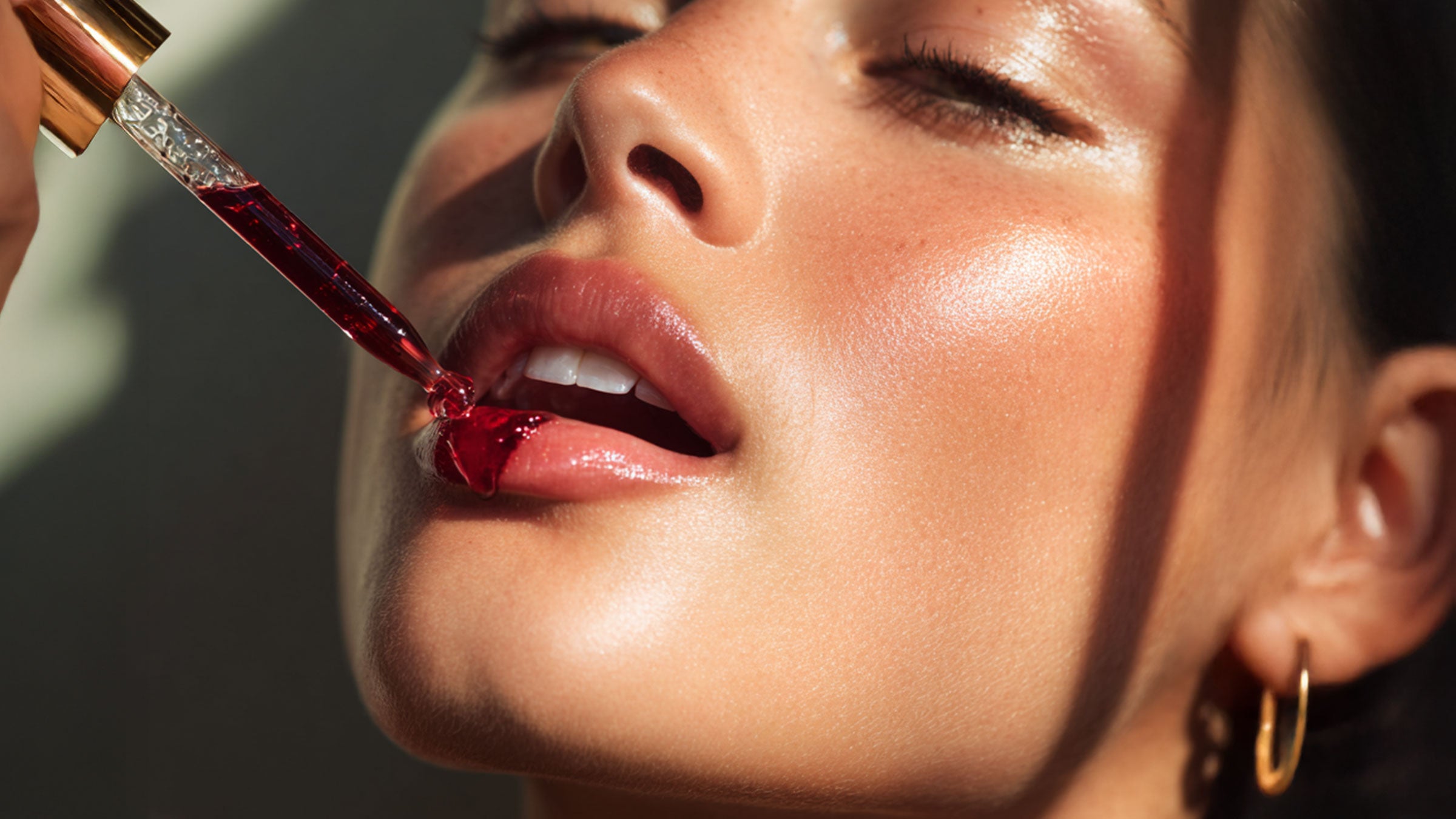 Close-up of a person applying Luxe Beauty Organic Astaxanthin Supplement to their lips.