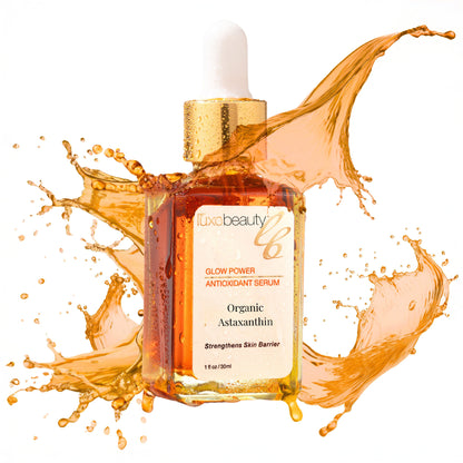 Luxe Beauty Organic Astaxanthin Serum bottle with splashes of liquid on a white background