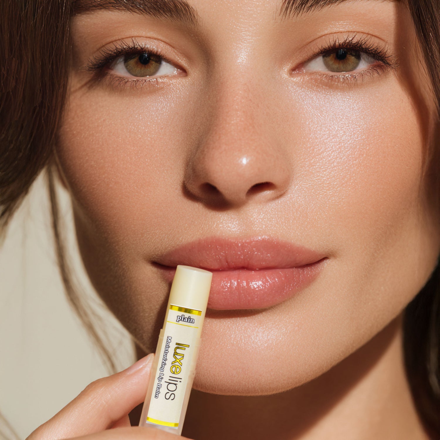 Close-up of a woman holding a Luxe Lips lip balm with a visible brand name.